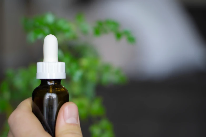 a close up of a person holding a bottle of oil, antipodeans, anaesthetic, lush and green, profile image, brown