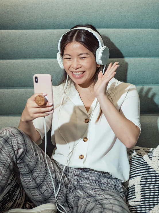 a woman sitting on a couch listening to headphones, inspired by Ruth Jên, trending on pexels, happening, mobile game, half asian, excited, profile image