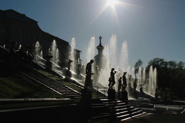 a group of people standing in front of a fountain, an album cover, by Alexey Venetsianov, pexels contest winner, neoclassicism, sun beam, russian city, bathing in light, thumbnail