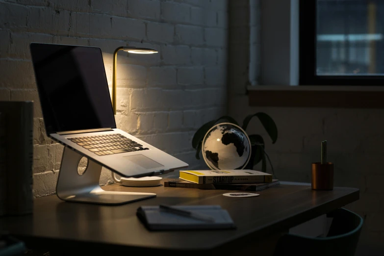 a laptop computer sitting on top of a wooden desk, by Adam Rex, unsplash contest winner, light and space, holding up a night lamp, good posture, ignant, spotlight at a 90 degree angle