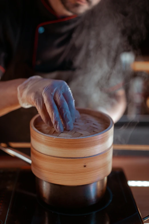 a man preparing food in a pot on a stove, a portrait, inspired by Kanō Naizen, trending on pexels, steamed buns, closeup - view, made of glazed, hands