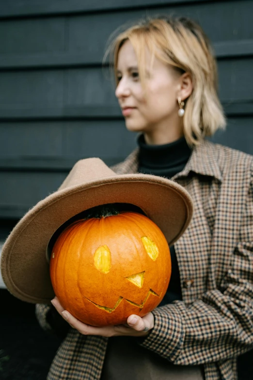 a woman in a hat holding a pumpkin, trending on pexels, zoe kazan, 6 : 3 0 am, style of jesper ejsing, festive