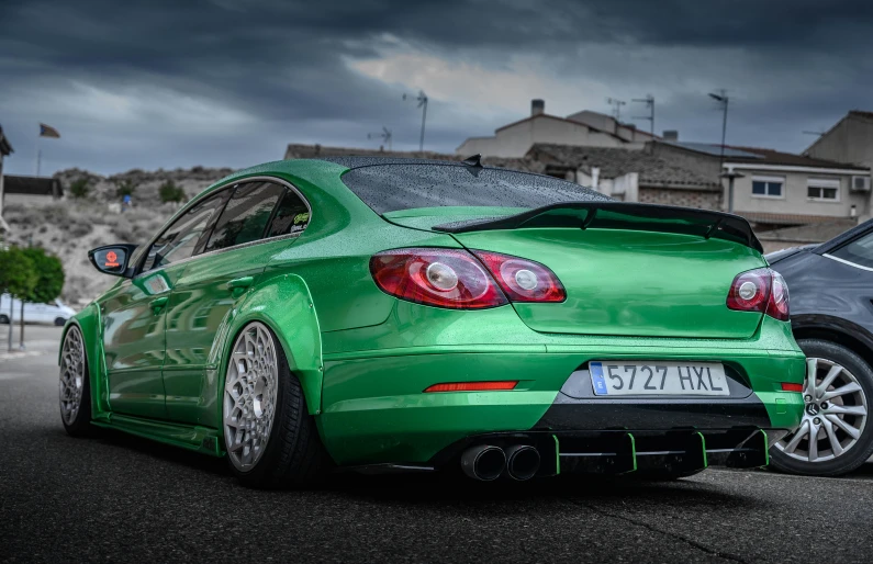 a green car parked on the side of the road, inspired by Harry Haenigsen, pexels contest winner, renaissance, half rear lighting, madrid. extreme long shot, samurai vinyl wrap, highly detailed hdr