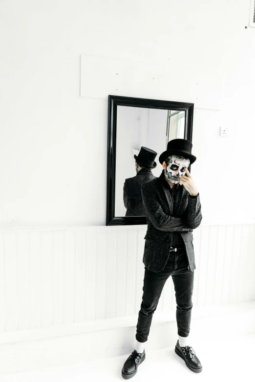 a man taking a picture of himself in a mirror, a black and white photo, by Caro Niederer, unsplash, vanitas, skull face paint, a suited man in a hat, full body with costume, in front of white back drop