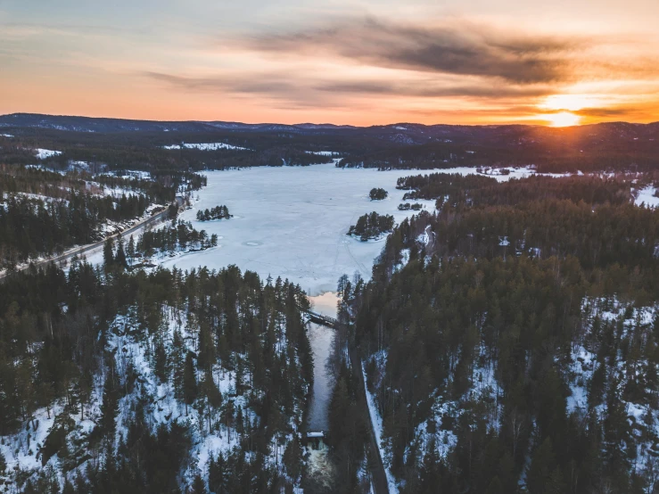 a large body of water surrounded by trees, by Jesper Knudsen, pexels contest winner, hurufiyya, snowy canyon at dawn, swedish countryside, hot sun from above, thumbnail