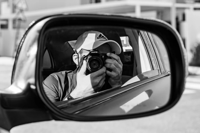 a man taking a picture of himself in a rear view mirror, a black and white photo, sony a7r -, photographs, photographer, profile picture