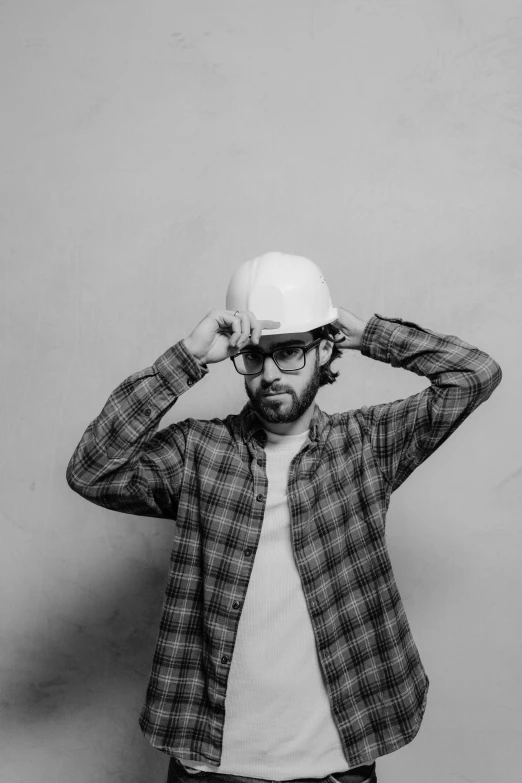 a black and white photo of a man wearing a hat, a black and white photo, pexels contest winner, photorealism, yellow hardhat, rhett and link, adrian tomine, stylish pose