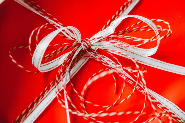 a close up of a red gift box with a white ribbon, pexels contest winner, strings, avatar image, bows, max dennison