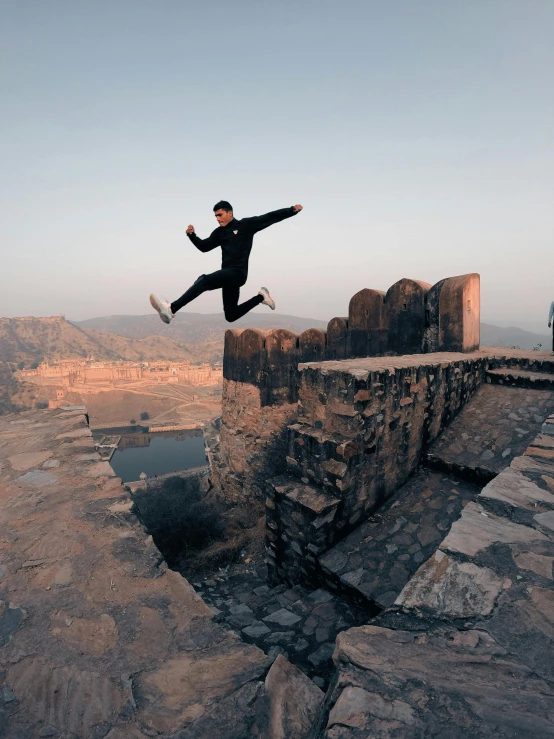 a man flying through the air while riding a skateboard, inspired by Steve McCurry, pexels contest winner, happening, great wall, hindu aesthetic, overlooking, in a jumping float pose