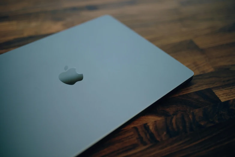 an apple laptop sitting on top of a wooden table, by Carey Morris, pexels, steel gray body, square, covered, processor