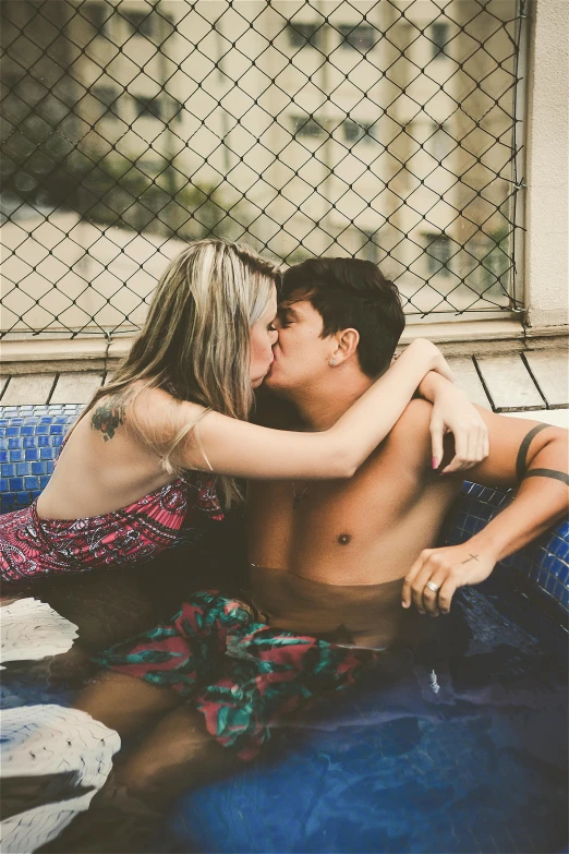 a man and a woman kissing in a pool, a colorized photo, trending on pexels, tattooed, teenager, beto val, profile image