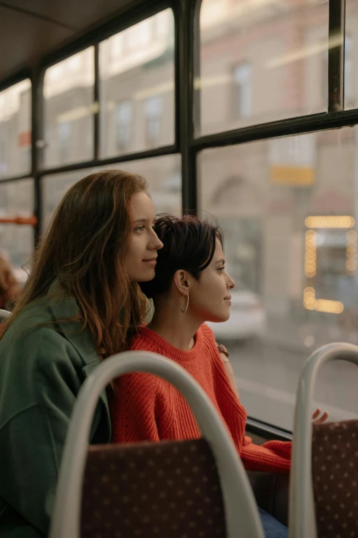 two women sitting on a bus looking out the window, trending on pexels, happening, ( ( theatrical ) ), square, julia gorokhova, orange line