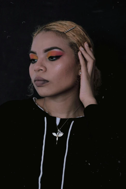 a woman standing in front of a black background, an album cover, inspired by Theo Constanté, trending on pexels, wearing eye shadow, wearing a black hoodie, orange hair, black jewelry