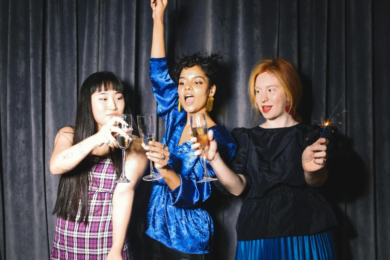 a group of women standing next to each other holding wine glasses, pexels contest winner, renaissance, fiona staples and kinu nishimura, hands in the air, photo booth, bisexual lighting