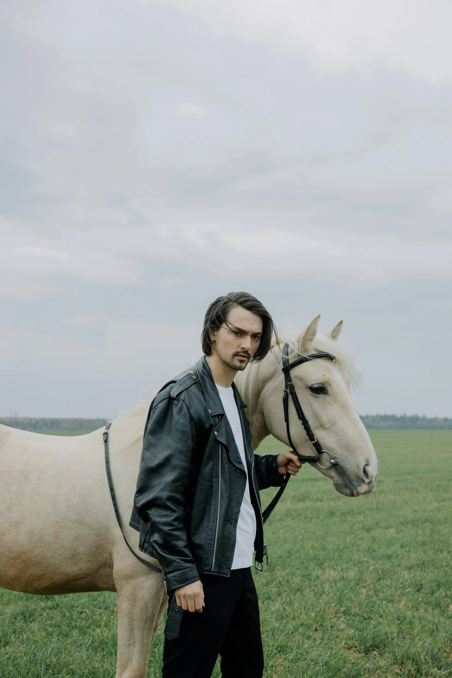 a man standing next to a white horse in a field, an album cover, by Adriaen Hanneman, trending on unsplash, romanticism, mid long hair, 15081959 21121991 01012000 4k, in russia, hozier