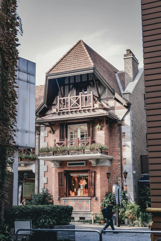 a person sitting on a bench in front of a building, by Daniel Seghers, pexels contest winner, art nouveau, chalet, gourmet restaurant, located in a wizard's shop, french village exterior