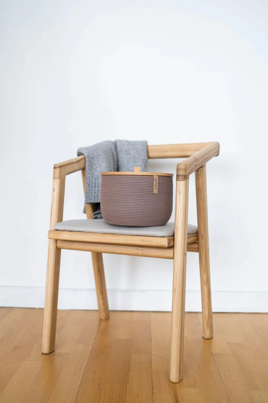 a wooden chair sitting on top of a hard wood floor, inspired by Constantin Hansen, unsplash, handbag, taupe, product view, pot