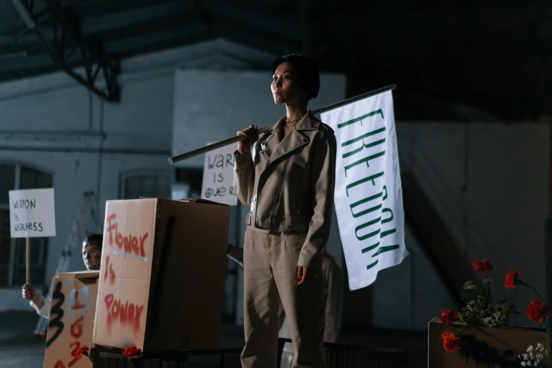 a woman holding a baseball bat standing next to a pile of boxes, unsplash, feminist art, performing on stage, banners with lenin, cinematic outfit photo, [ theatrical ]