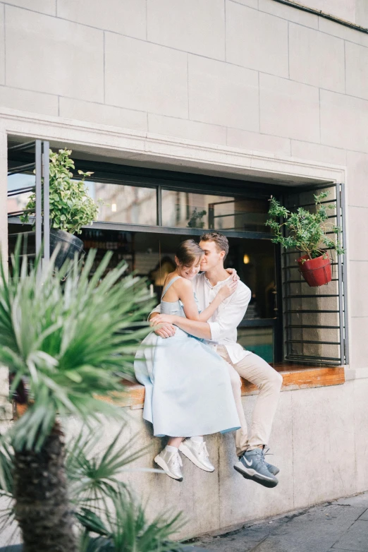 a man and a woman sitting on a window sill, by Julia Pishtar, trending on unsplash, romanticism, in a bright cafe, manila, romantic greenery, embracing