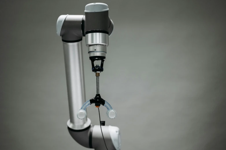 a close up of a machine with wires attached to it, a digital rendering, inspired by Robert Zünd, unsplash, robotic prosthetic arm, on grey background, gray, aluminium