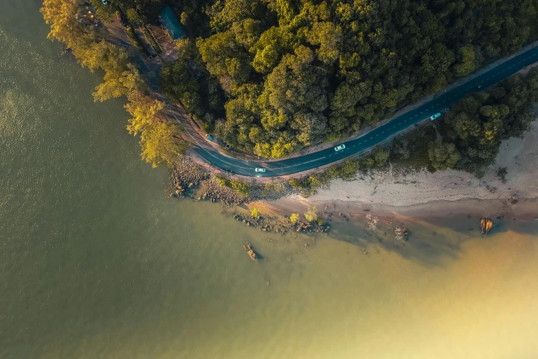 an aerial view of a road next to a body of water, pexels contest winner, thumbnail, great quality, gold, low iso