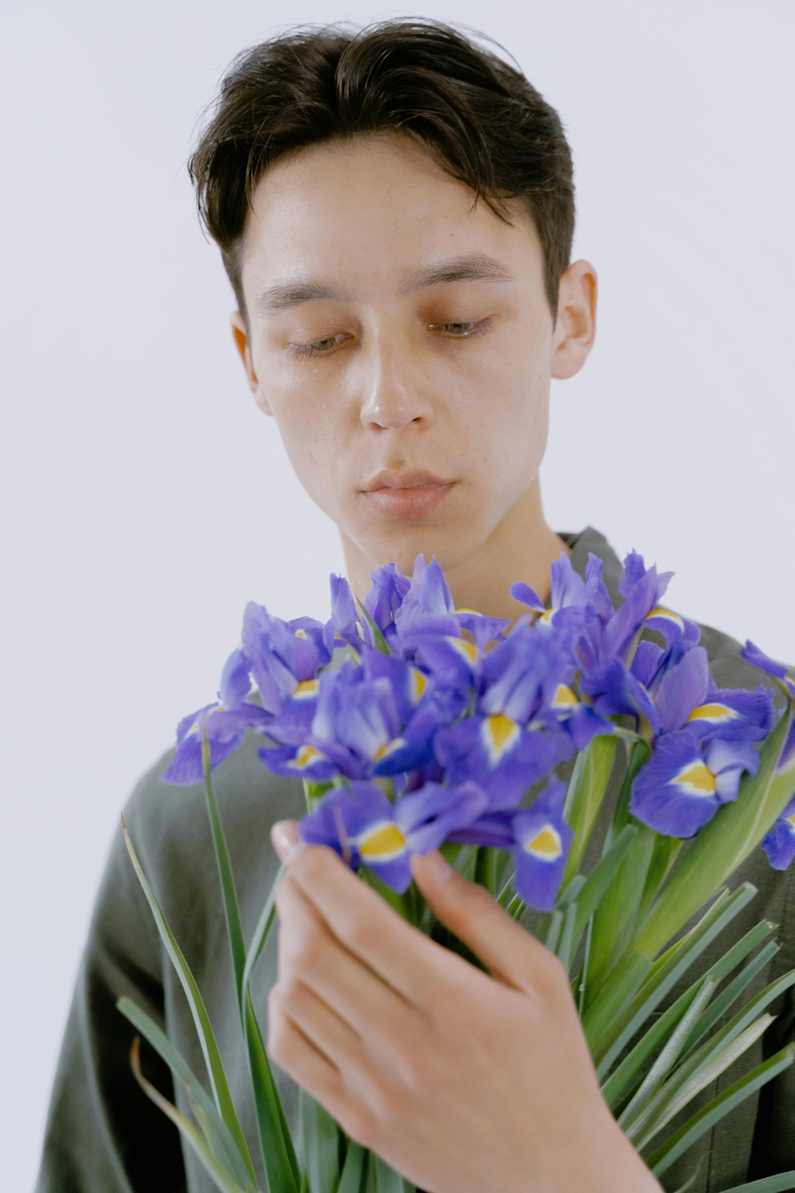 a young man holding a bunch of purple flowers, an album cover, inspired by Jean Malouel, kiko mizuhara, soulful irises, showstudio, still frame from a movie