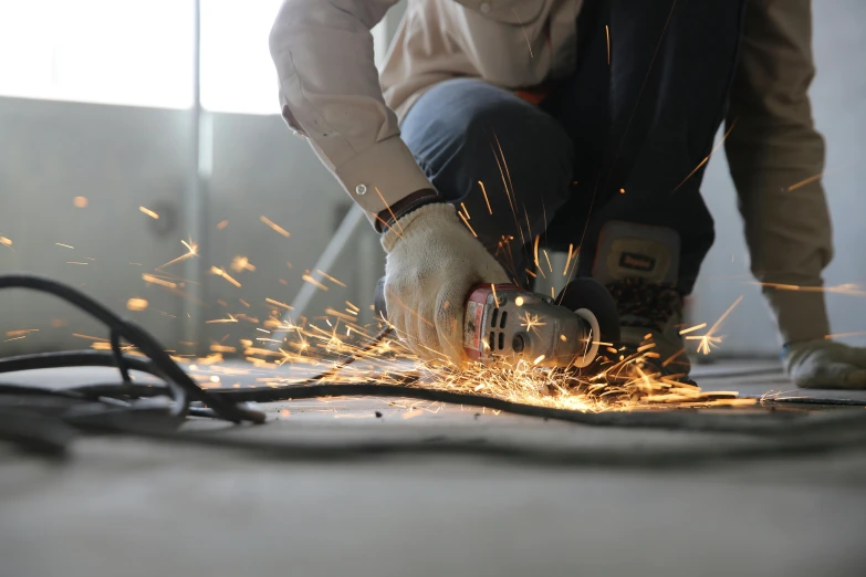 a person cutting a piece of metal with a grinder, pexels contest winner, arbeitsrat für kunst, full body hero, electrical arcs, thumbnail, ground level shot