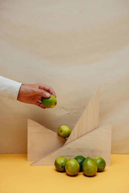 a person holding an apple over a pile of green apples, an abstract sculpture, by Jessie Algie, trending on tumblr, kinetic art, geometric wood carvings, product display photograph, avocados, insisted on cutting in line