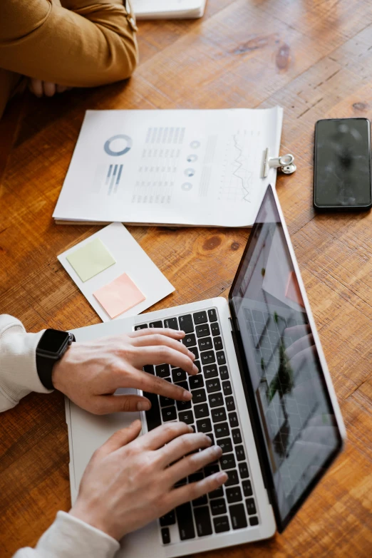 a person sitting at a table working on a laptop, pexels, items and gadget, multiple stories, uploaded, charts