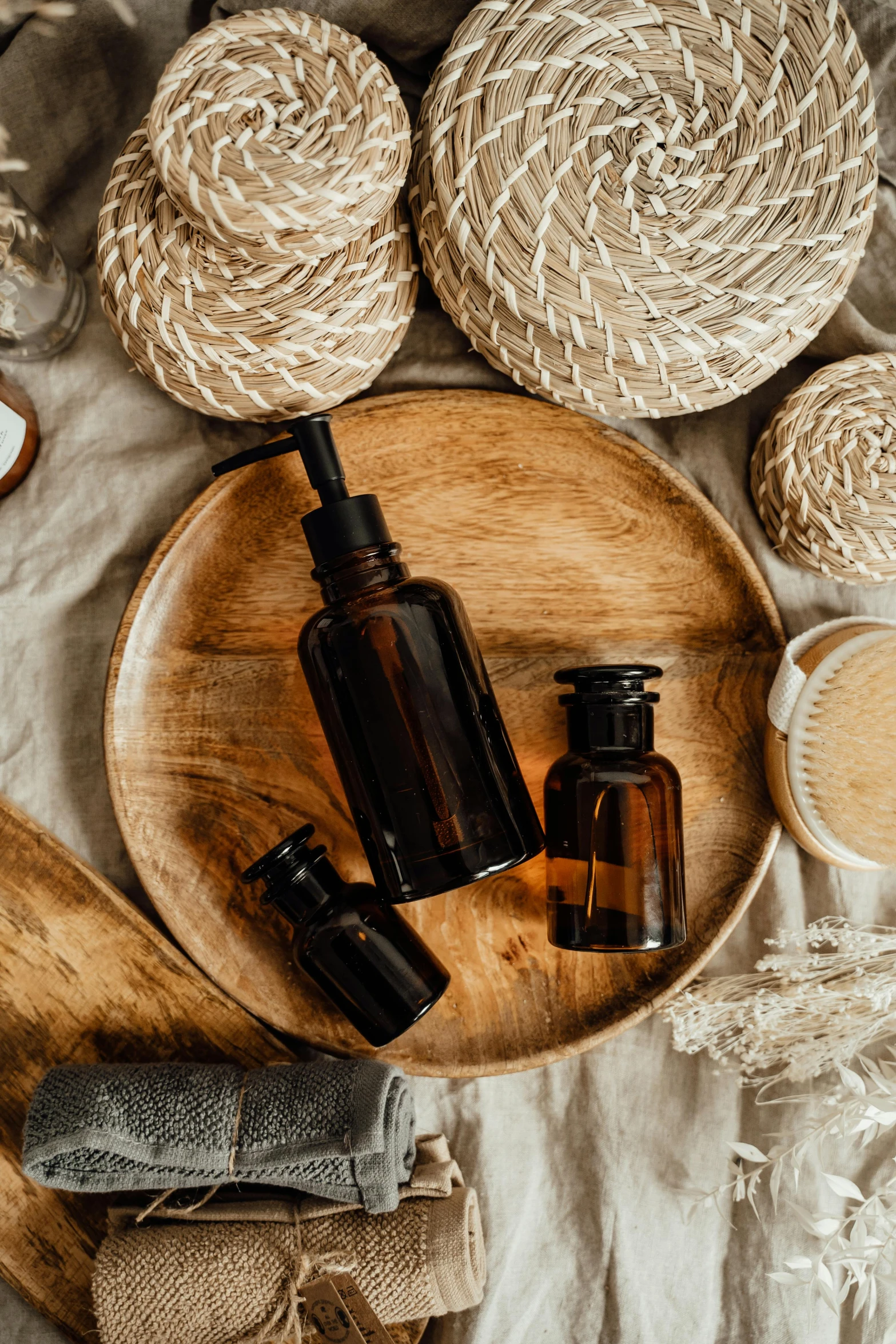 a wooden plate topped with bottles of essential oils, a still life, trending on pexels, renaissance, brown, thumbnail, modern rustic, black