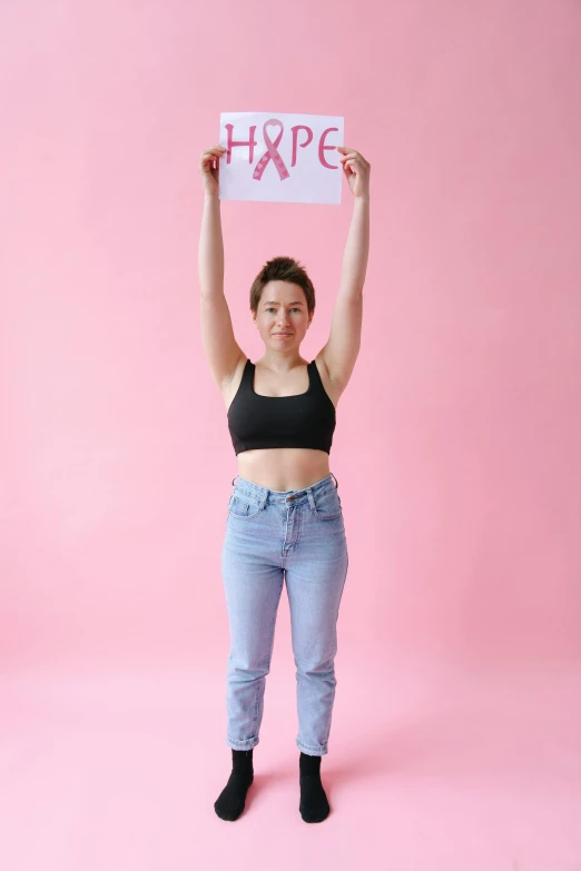 a woman holding up a sign that says hope, pexels contest winner, pink body, hip-length, kailee mandel, max prentis