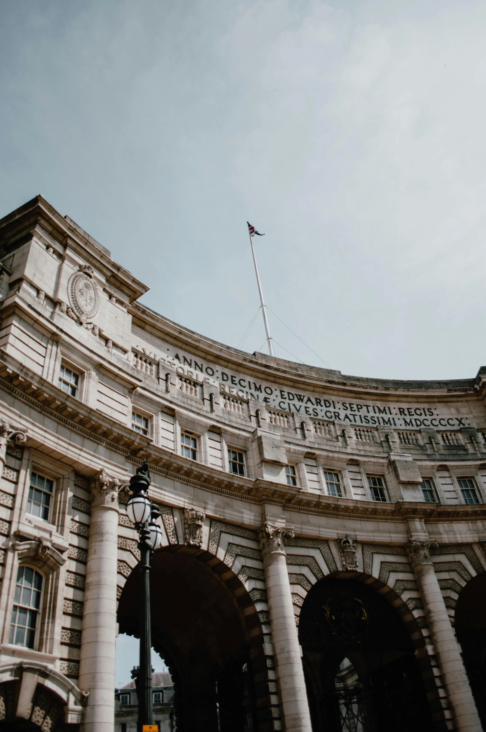 a tall building with a clock on top of it, pexels contest winner, neoclassicism, archway, united kingdom flags, rounded roof, curls