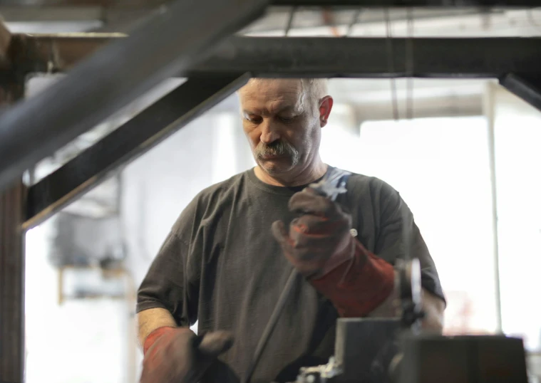 a man working on a machine in a factory, a portrait, arbeitsrat für kunst, blacksmith product design, portrait image