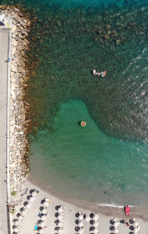 a large body of water next to a beach, a picture, happening, top-down shot, looking towards camera, floating, manly
