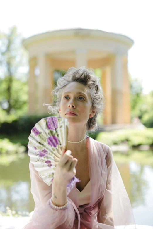 a woman in a pink dress holding a fan, inspired by Konstantin Somov, unsplash, rococo, film still promotional image, a blond, wearing silver silk robe, calm weather