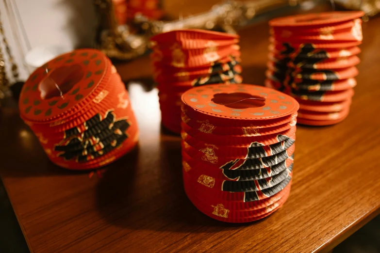 a group of red boxes sitting on top of a wooden table, by Emma Andijewska, pexels contest winner, arts and crafts movement, the lantern crown, traditional chinese, cans, paper decoration