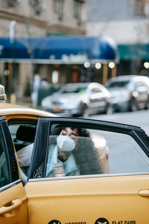 a man in a face mask getting out of a taxi, trending on pexels, square, nyc, sitting in her car, top - down photograph