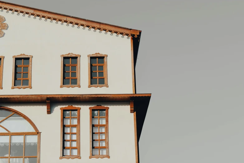 a clock that is on the side of a building, by Matthias Weischer, pexels contest winner, hyperrealism, moorish architecture, bay window, brown and white color scheme, minimalist structure