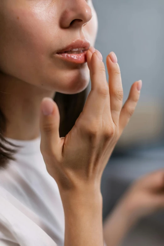 a close up of a person holding a cell phone, pointé pose;pursed lips, partially cupping her hands, skincare, doing a prayer