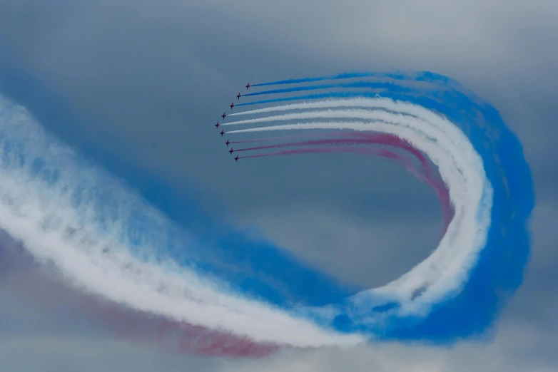 a group of jets flying through a cloudy sky, by Helen Biggar, pexels contest winner, brand colours are red and blue, curved lines, olympics, medium closeup