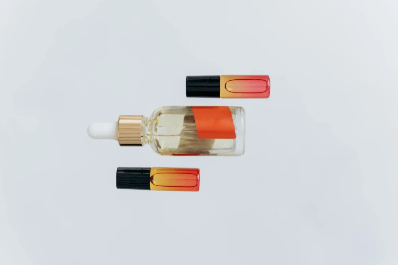 two bottles of perfume on a white surface, an album cover, unsplash, gradient red to yellow, vials, 5 7 9, 9