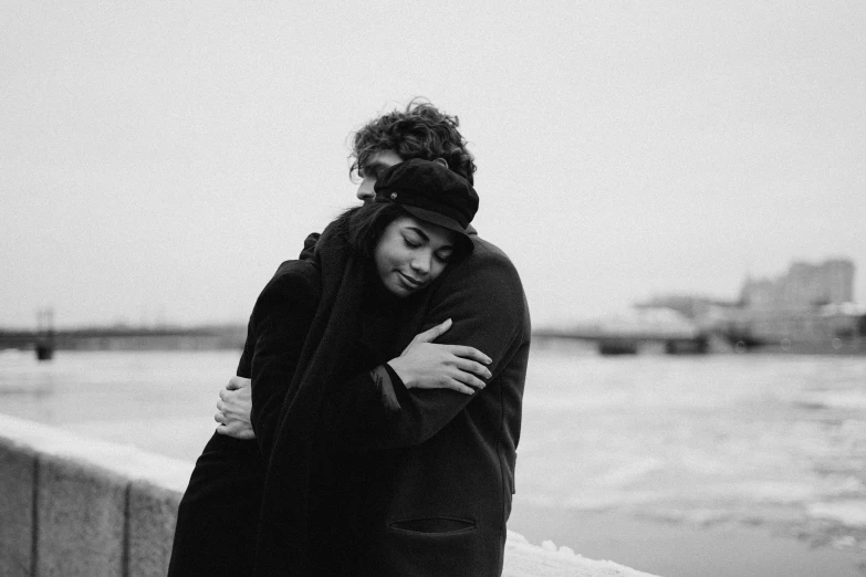 a black and white photo of two people hugging each other, a black and white photo, by Emma Andijewska, pexels, cold weather, smooth in _ the background, high quality upload, russian