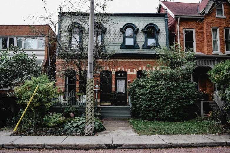 a couple of houses sitting on the side of a street, by Carey Morris, pexels contest winner, art nouveau, toronto, 33mm photo, a cozy old victorian loft, built on a small