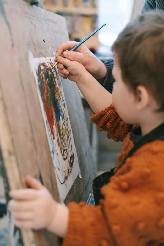 a little boy that is painting on a canvas, a child's drawing, inspired by Hendrick Avercamp, trending on pexels, process art, painting on a badge, highly intricate, rubens, concentration