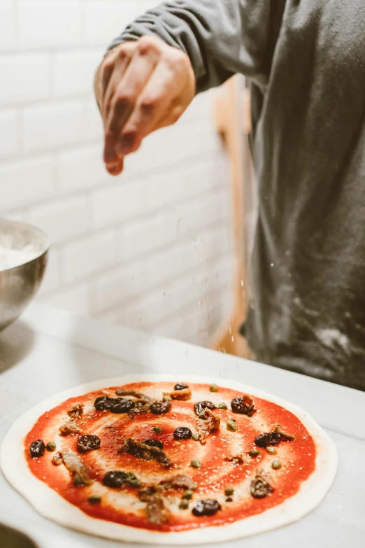 a person putting toppings on a pizza on a counter, pexels contest winner, renaissance, back towards camera, tall, banner, plating