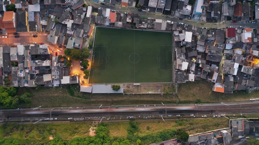 an aerial view of a soccer field in a city, an album cover, by Daniel Lieske, unsplash contest winner, location ( favela ), early evening, square, game ready