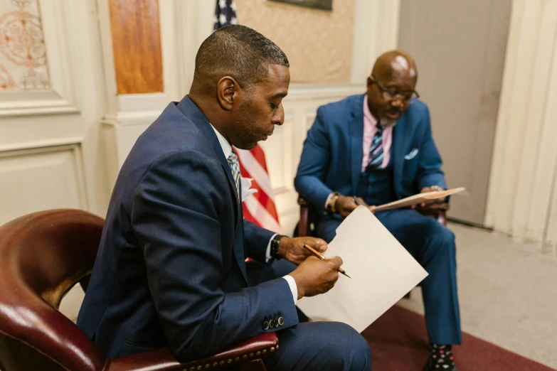 two men sitting next to each other in a room, by Dan Frazier, pexels contest winner, signing a bill, jemal shabazz, ray lewis, official media