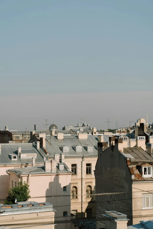 a large clock tower towering over a city, inspired by Illarion Pryanishnikov, unsplash, baroque, skyline view from a rooftop, smoke from chimneys, pale beige sky, summer evening