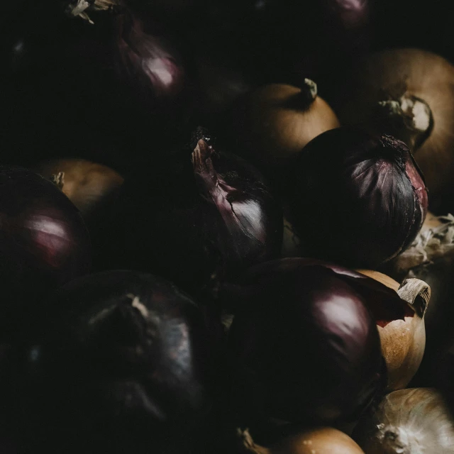 a pile of onions sitting on top of a table, by Alejandro Obregón, trending on unsplash, baroque, dark red and black color palette, round format, jovana rikalo, michelangelo da caravaggio