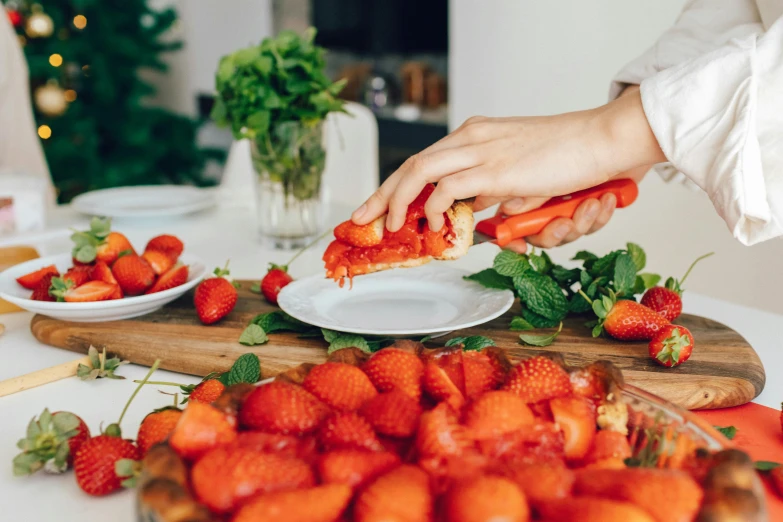 a person cutting strawberries on a cutting board, by Julia Pishtar, pexels contest winner, at a dinner table, profile image, holiday, 🦩🪐🐞👩🏻🦳